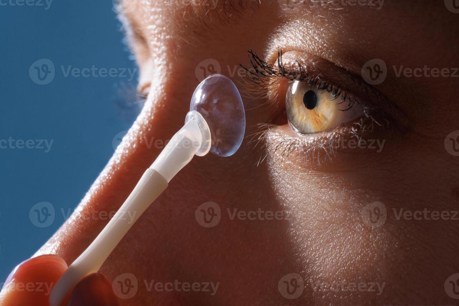 Inserting a contact lens into the eye photo