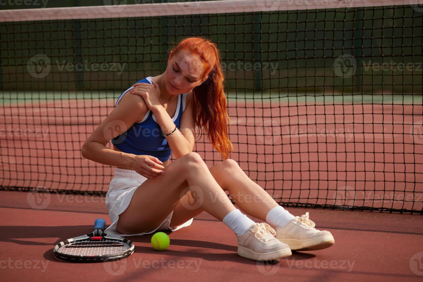 Tennis player sitting on court photo