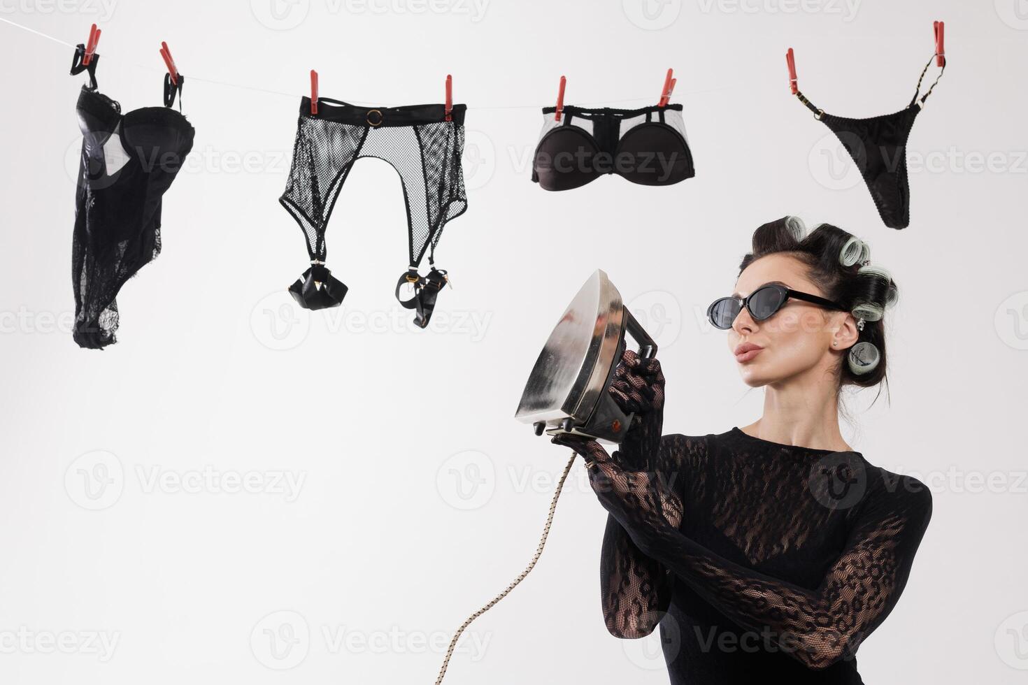 Woman ironing lingerie on clothesline photo