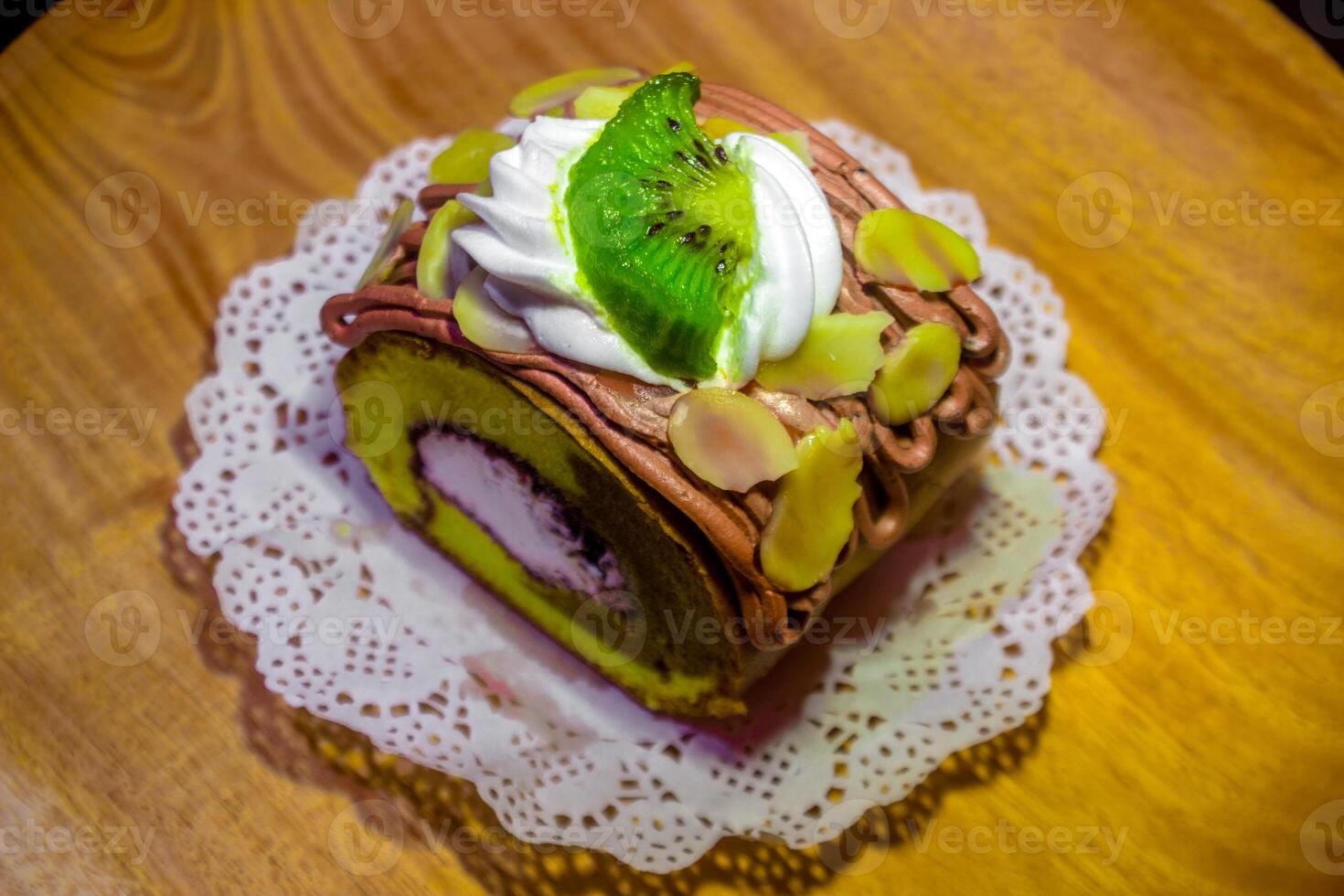 A piece of cake with a kiwi on top photo