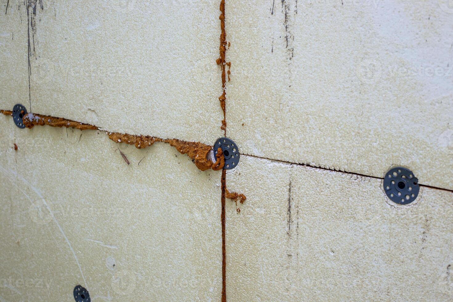Close-up of external wall insulation with polystyrene foam with fasteners and sealant showing construction details photo