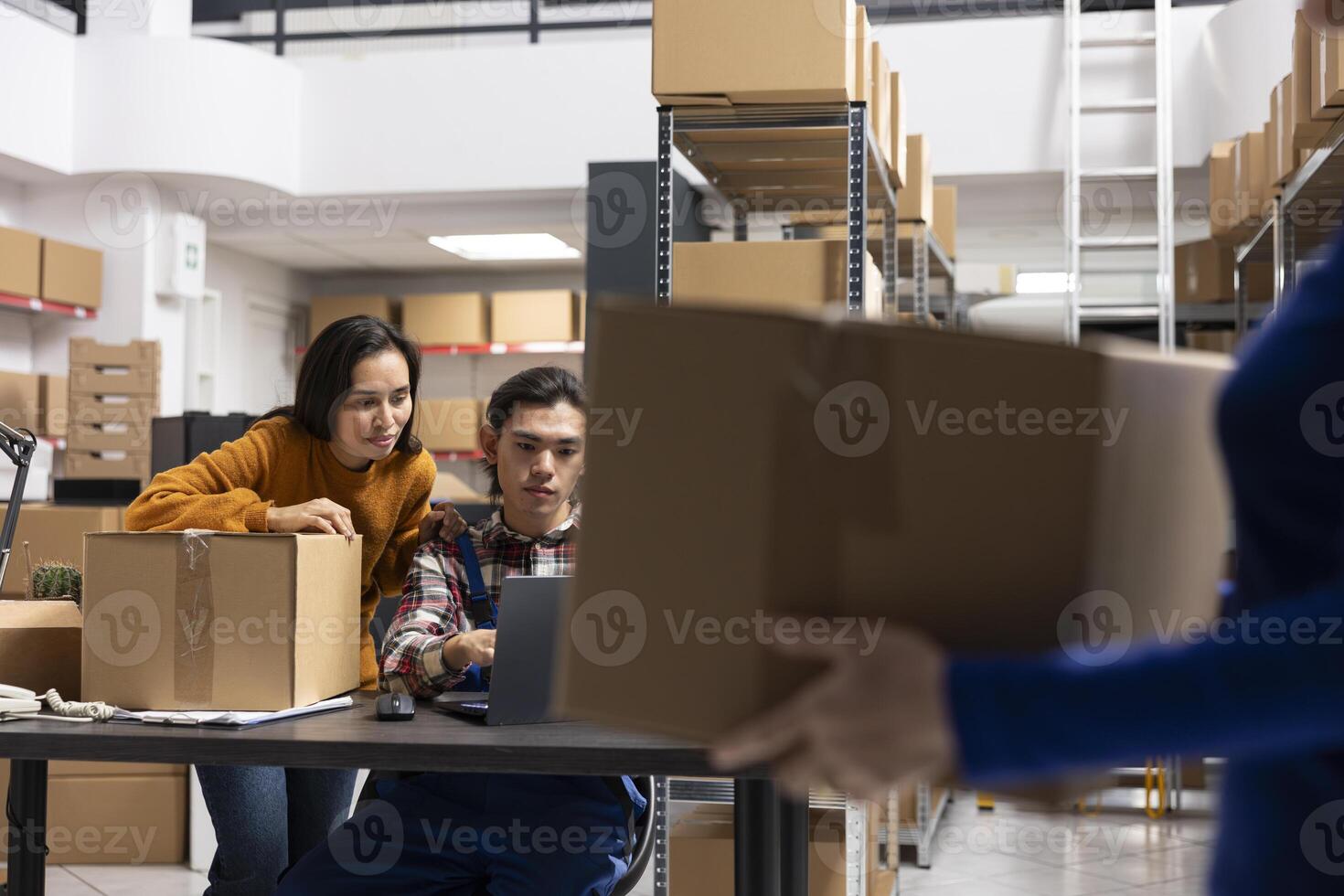 Workers team processing orders and retail shipments in small storehouse with taped boxes and labeled parcels. Local brand fulfillment supported by efficient logistics and delivery services. photo