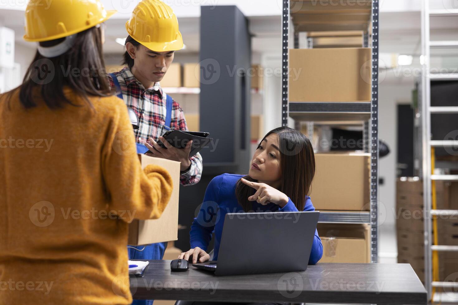 Asian staff members at a fulfillment center printing invoices and prepares packages with bar codes and shipping labels. Small business handles local delivery and in house order processing. photo
