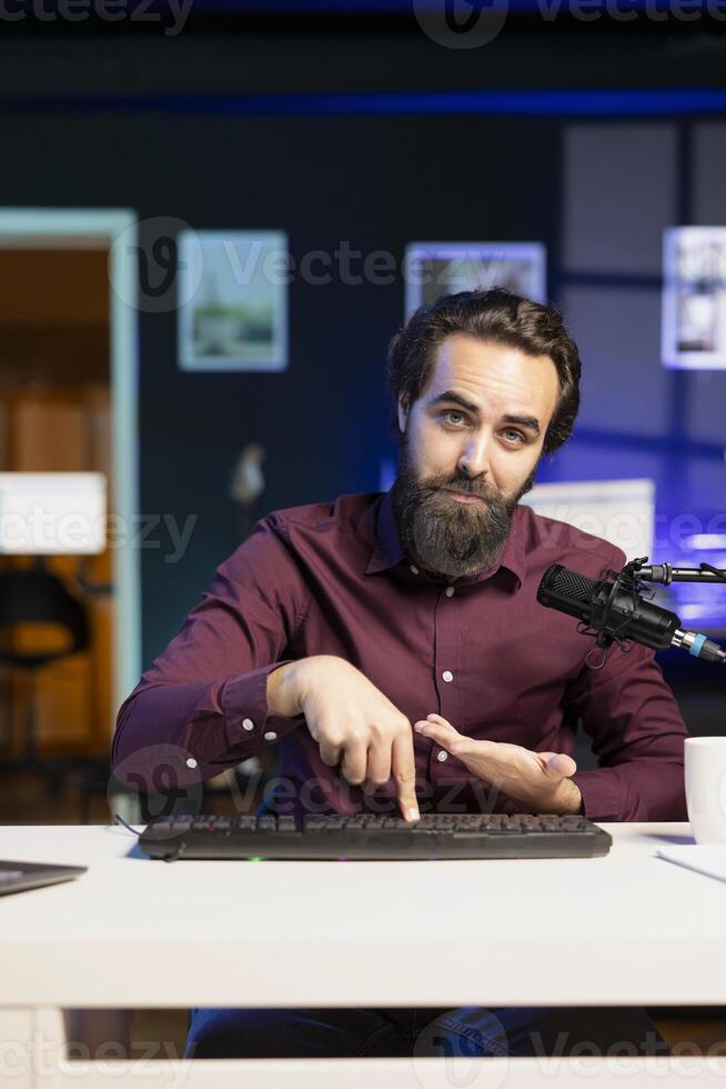 Man filming keyboard disassembly guide doing tutorial on how to do maintenance. Technology internet show host teaching subscribers how to clean and fix individual keyboard keys photo