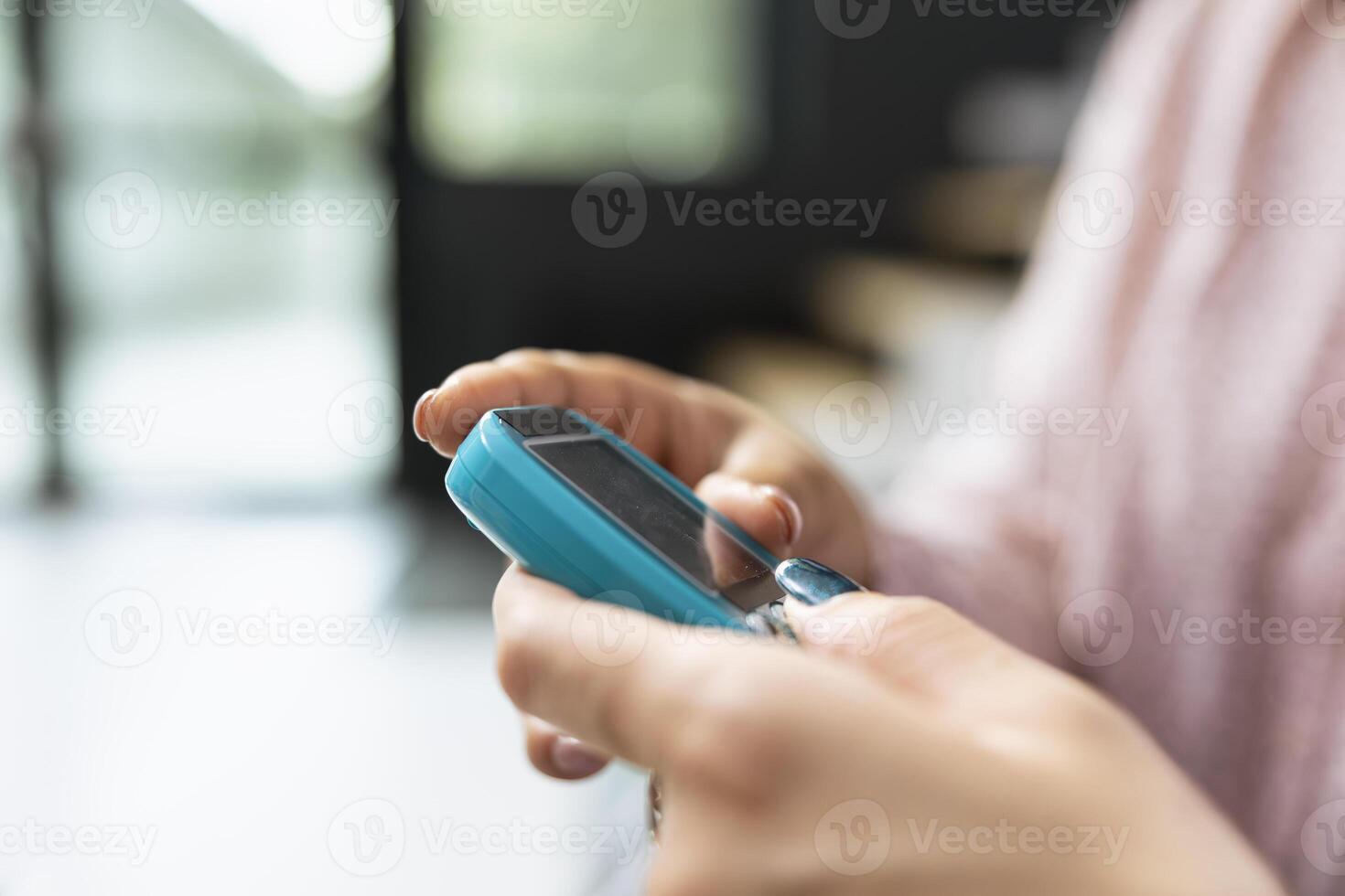 Nurse checking blood sugar levels using glucometer device, routine health check in hospital waiting room. Asian woman receiving support and learning to track glucose levels. Close up. photo