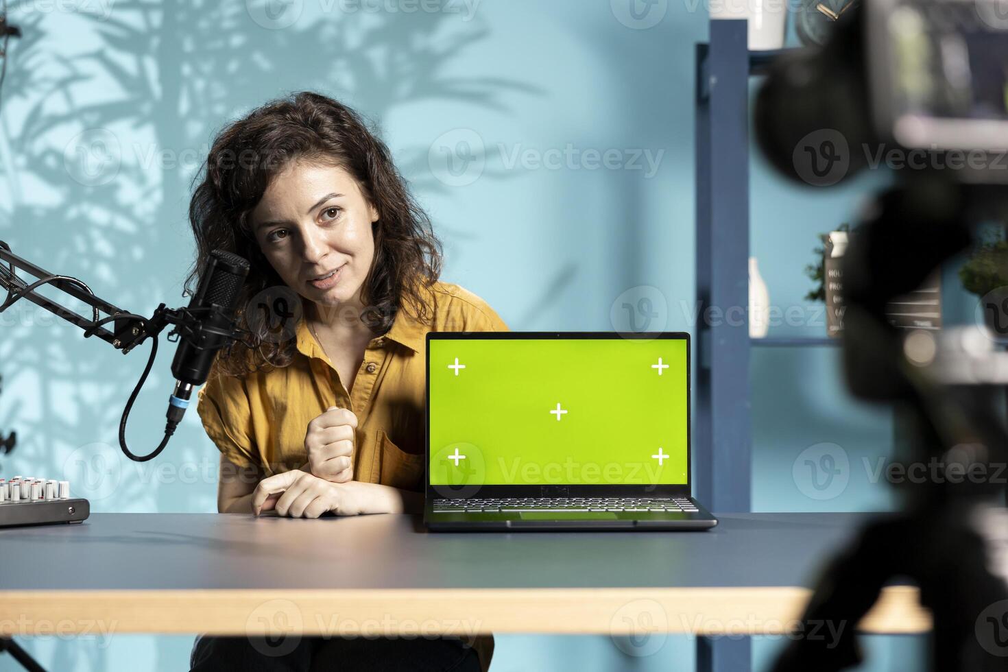 Tech specialist assessing mockup laptop performance, talking about parts used inside, filming with professional camera. Entertainer reviewing green screen notebook on technology internet channel photo