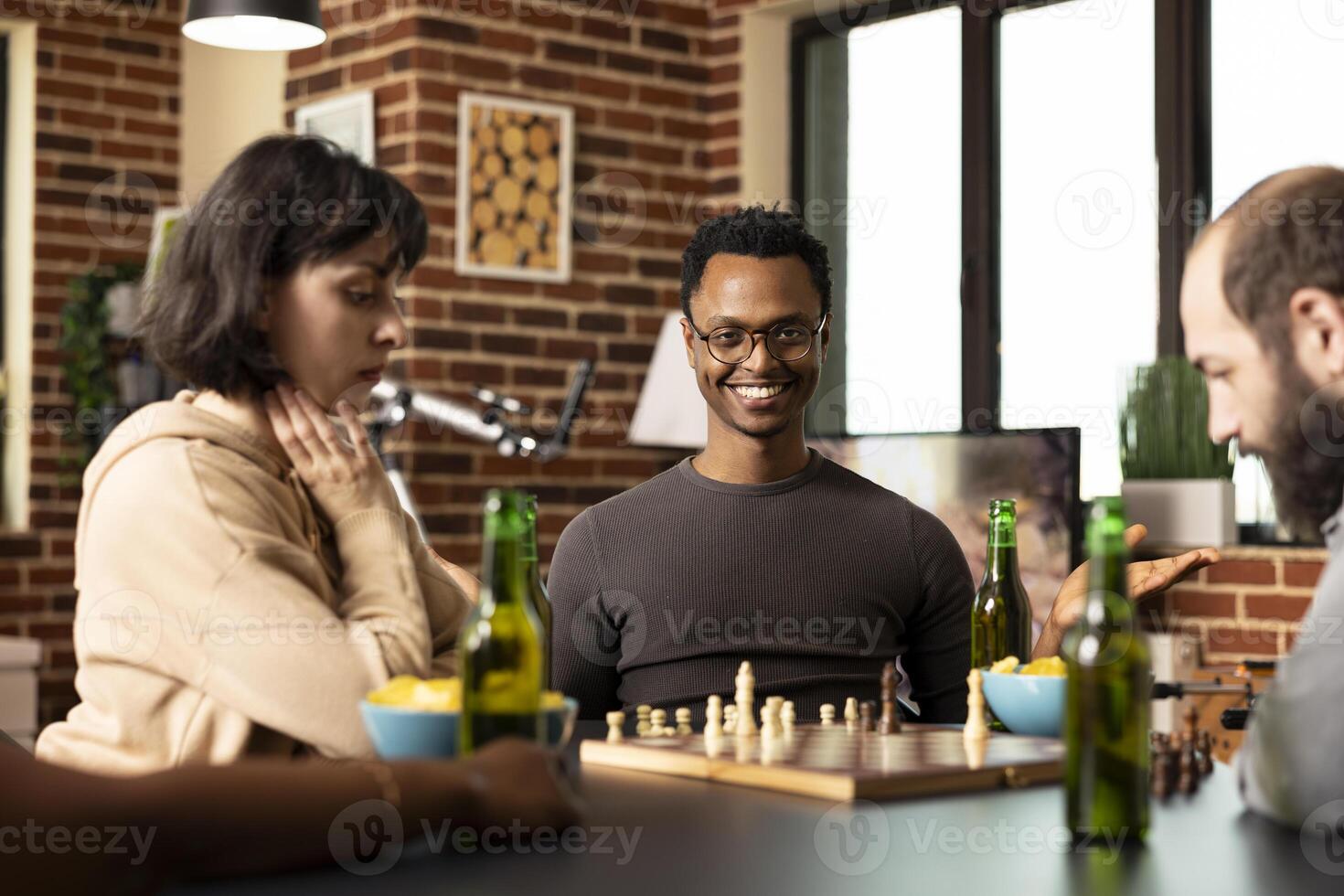 Friends playing chess with drinks photo