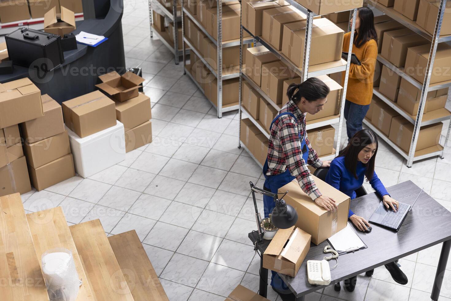 Local brand supply room staff work at distribution hub for order processing and hand packing merchandise. Ensuring local shipping and in house logistics operations for retail fulfillment. photo