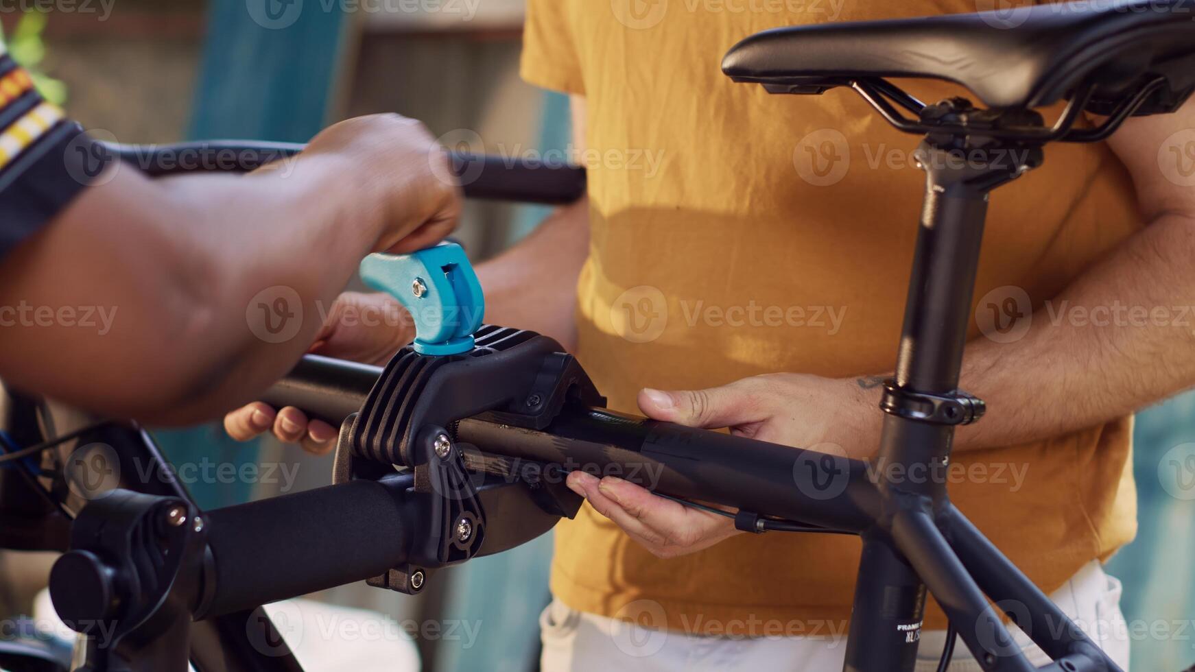 Detailed view of boyfriend and girlfriend fixing bicycle damages in backyard using specialized repair-stand and tools. Close-up of multiethnic couple grasping and clamping bike for maintenance. photo