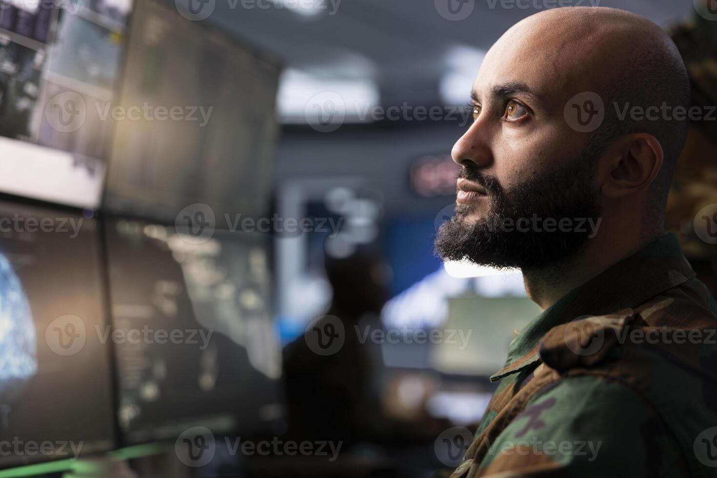Army telecommunication systems agent using radio and satellite tech, providing combat support. Middle Eastern soldier managing communications networks, looking at monitors photo