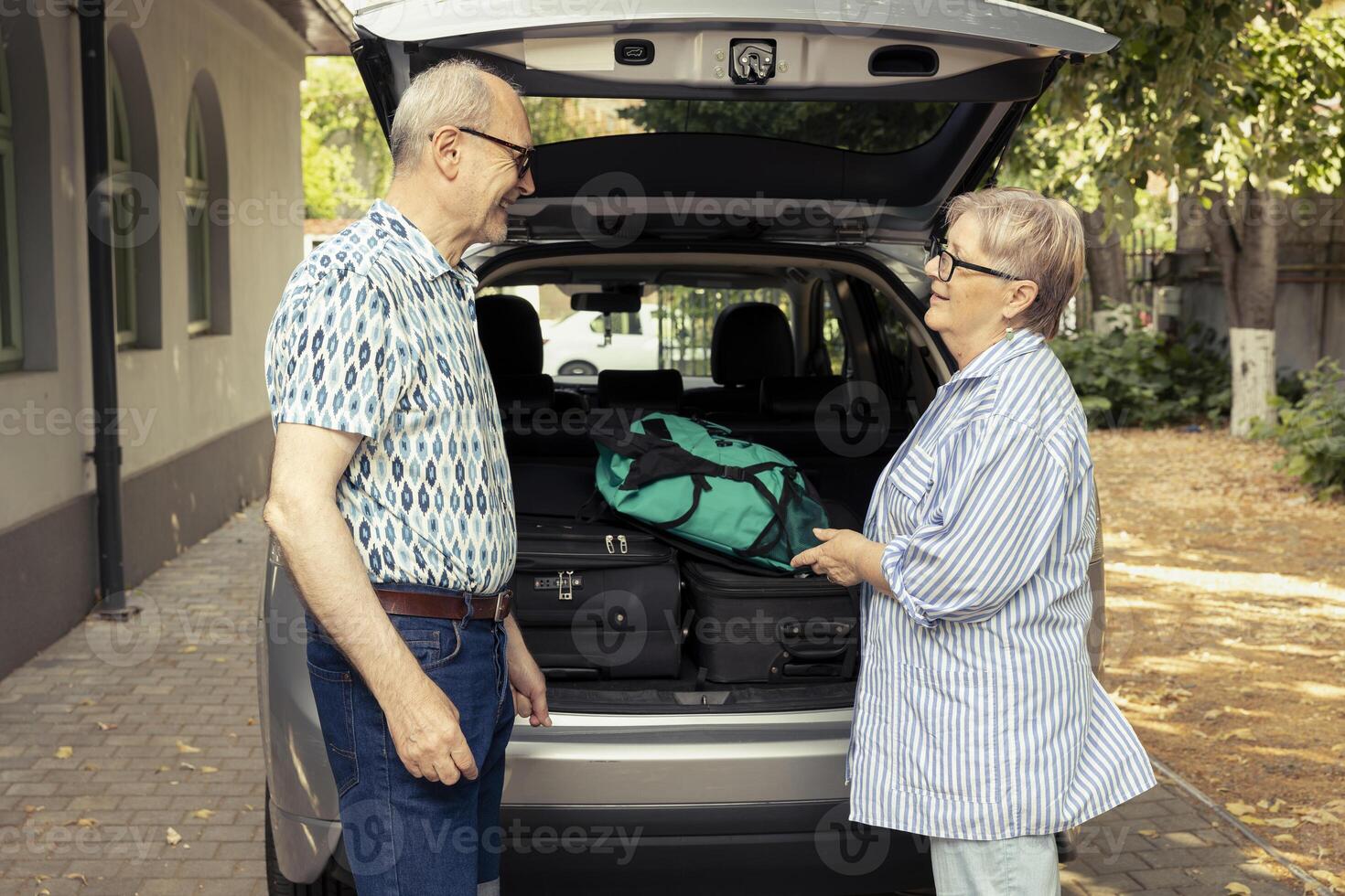 Senior people prepare their automobile for an exciting road trip during summer, loading suitcases and road essentials into the trunk. Retirement brings freedom and exploration for couple. photo