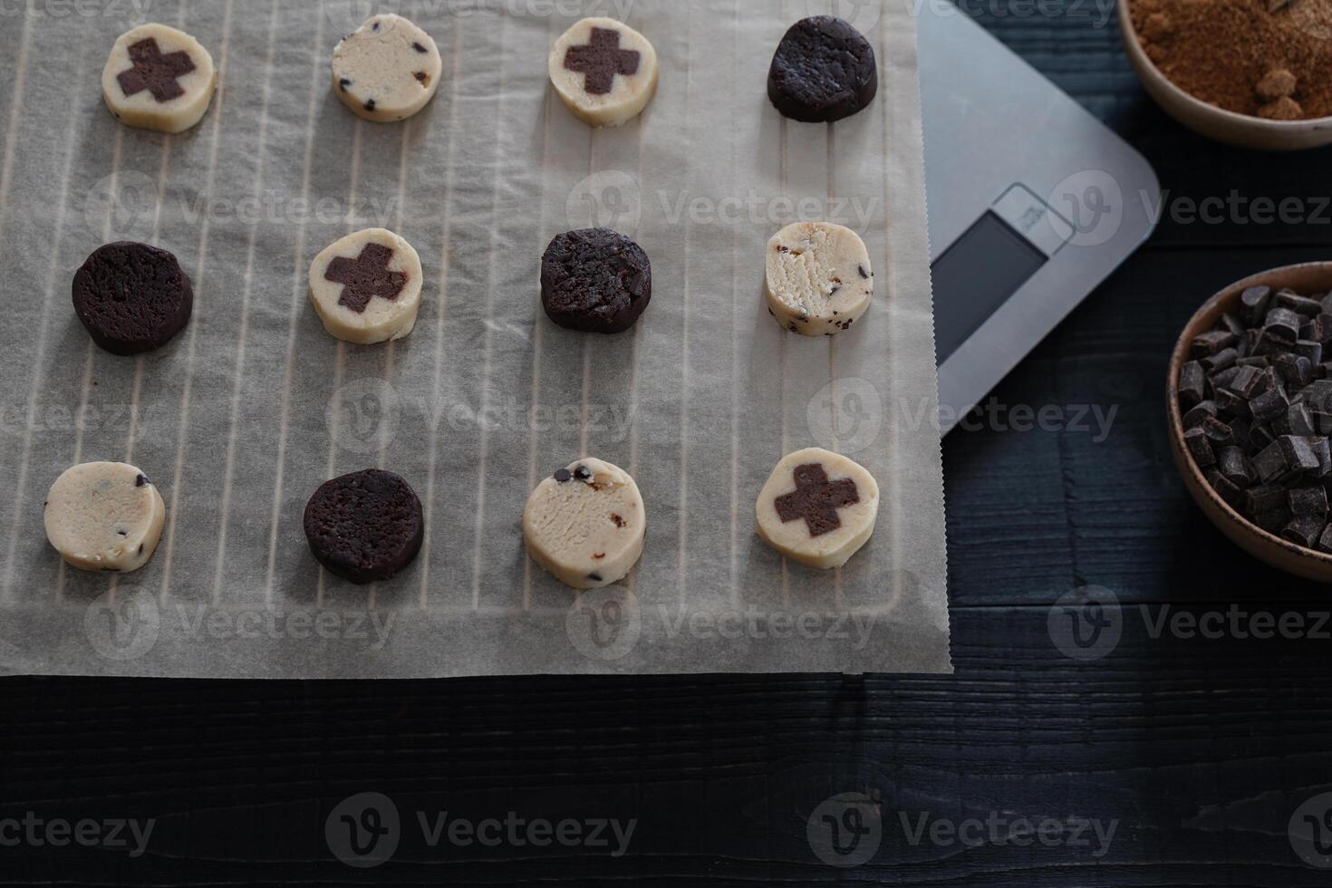 Cookie dough ready to bake with chocolate chips and sugar on dark wooden background photo