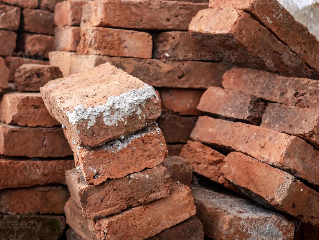 red bricks arranged crookedly with white cement stains on one side photo