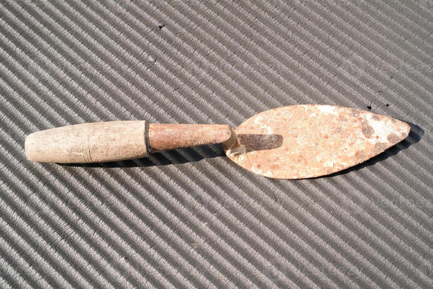 A rusty trowel with a wooden handle isolated on black backgrounds. Hand shovel used for planting plants in pots or digging soil. Tool and equipment for gardening . Graphic resources. Text space photo