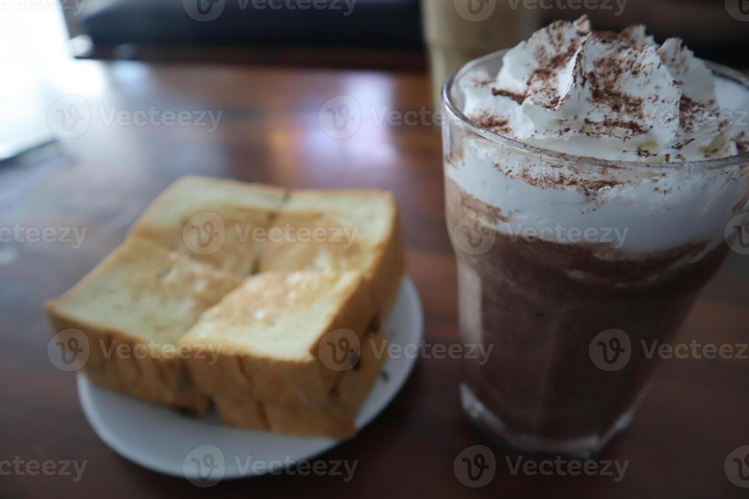 A glass of chocolate milk and a slice of bread photo