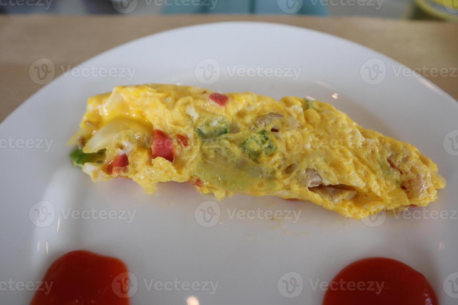 A plate with an omelet and some ketchup on it photo