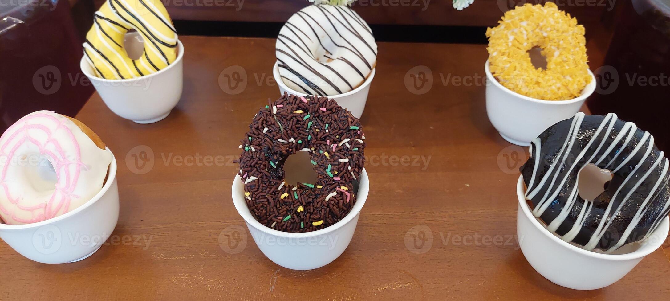 A table with a bunch of donuts in white cups photo