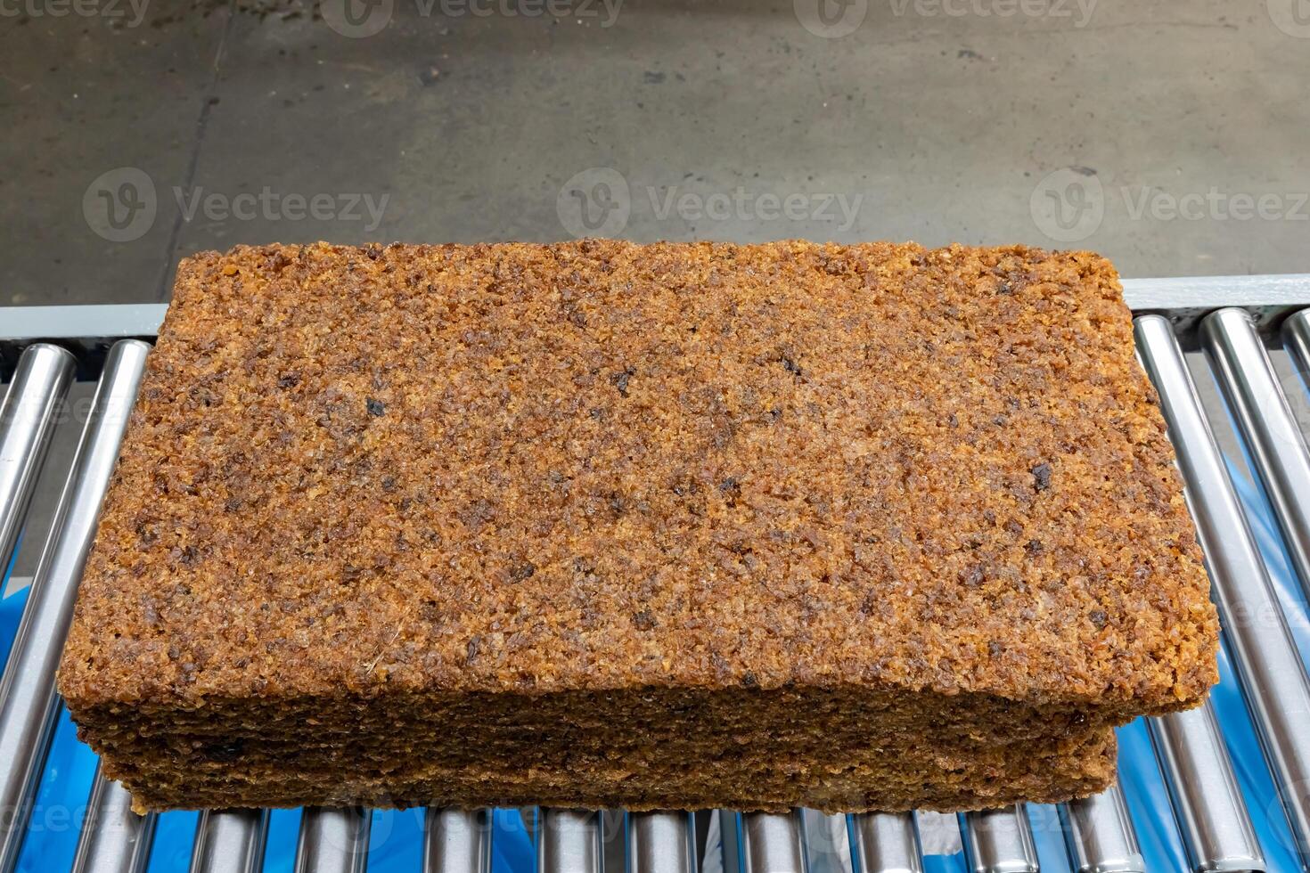 The natural rubber bales products on the industrial automatic conveyor belt machine in a rubber factory.a photo