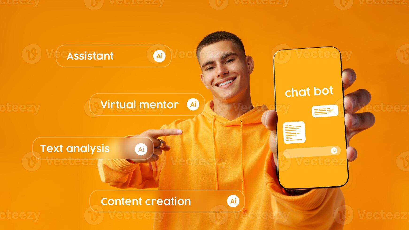 Young man shows smartphone displaying chatbot features against a bright orange background in a modern workspace photo