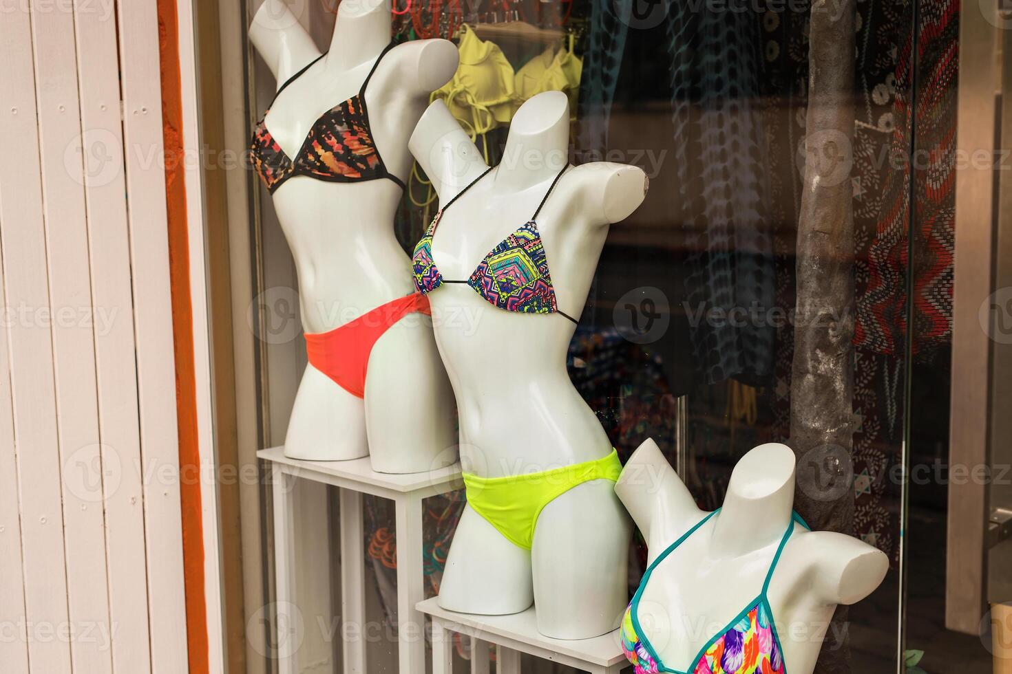 Women's swimsuits on mannequins for sale at a seaside shop. photo