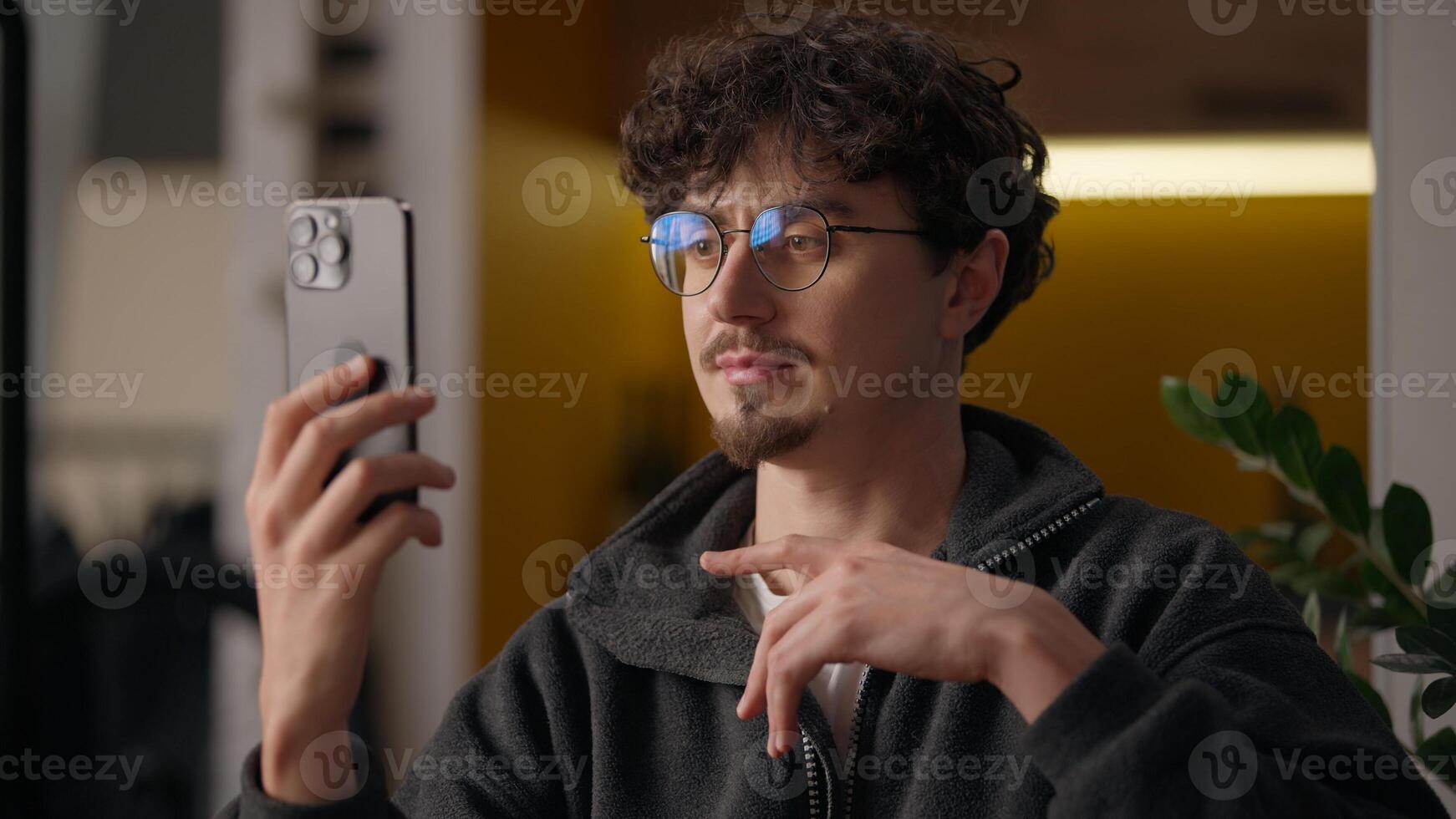 Caucasian guy hipster talking conference holding mobile phone at home freelancer man conversation distant call cellphone communication blogger male speaking influencer recording vlog blogging photo