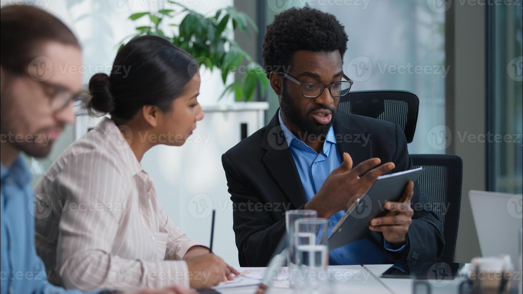 Business people teamwork multiethnic women men group businessmen businesswoman leader CEO boss talking discuss explain startup project writing notes briefing in office co-workers colleagues corporate photo
