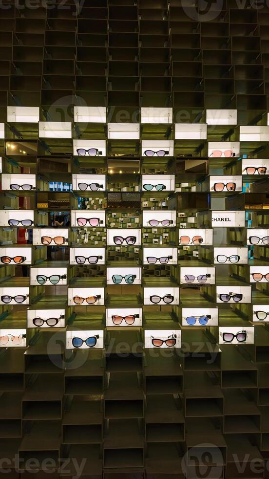 Organized eyewear display. Retail store image for commercial, marketing, or product catalog use, showing various eyeglasses on illuminated shelves. photo