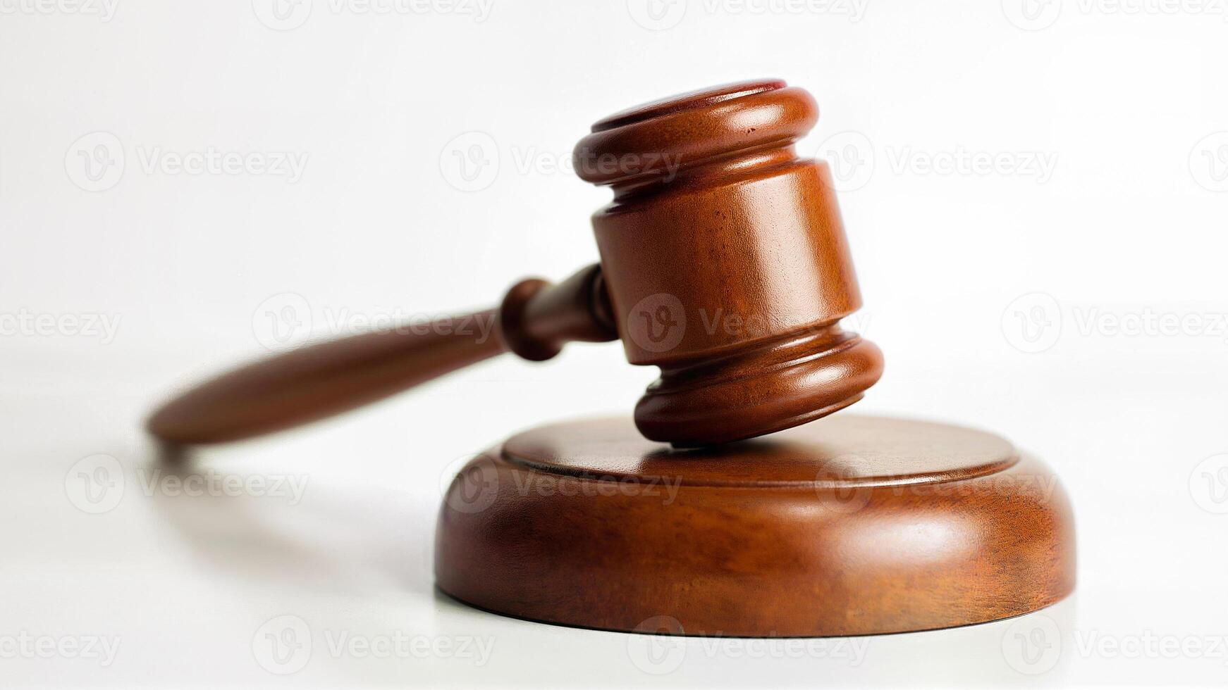 A wooden judge gavel rests on a matching sound block, isolated on a white background. Suitable for legal, justice, court, or law-related content and educational materials. photo