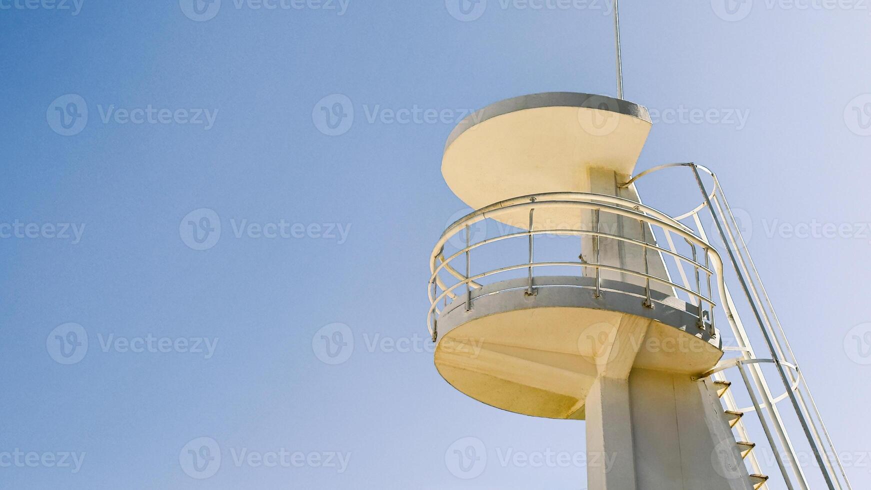 White lifeguard tower on blue sky as a background. Image suitable for beach safety, tourism, or coastal architecture context. Copy space for text. photo