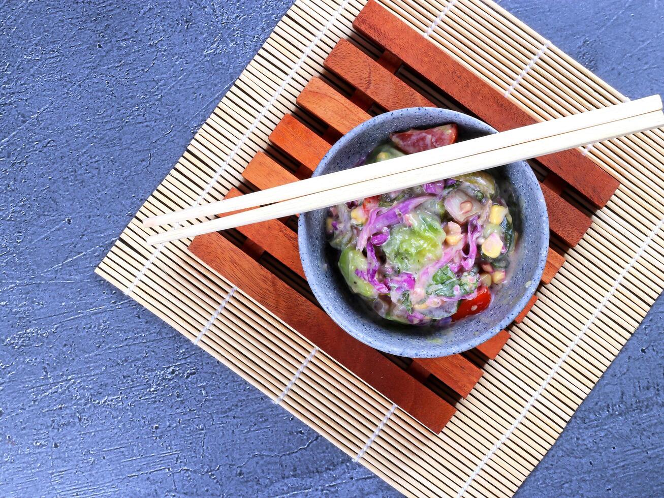 Bowl of Asian salad with chopsticks photo