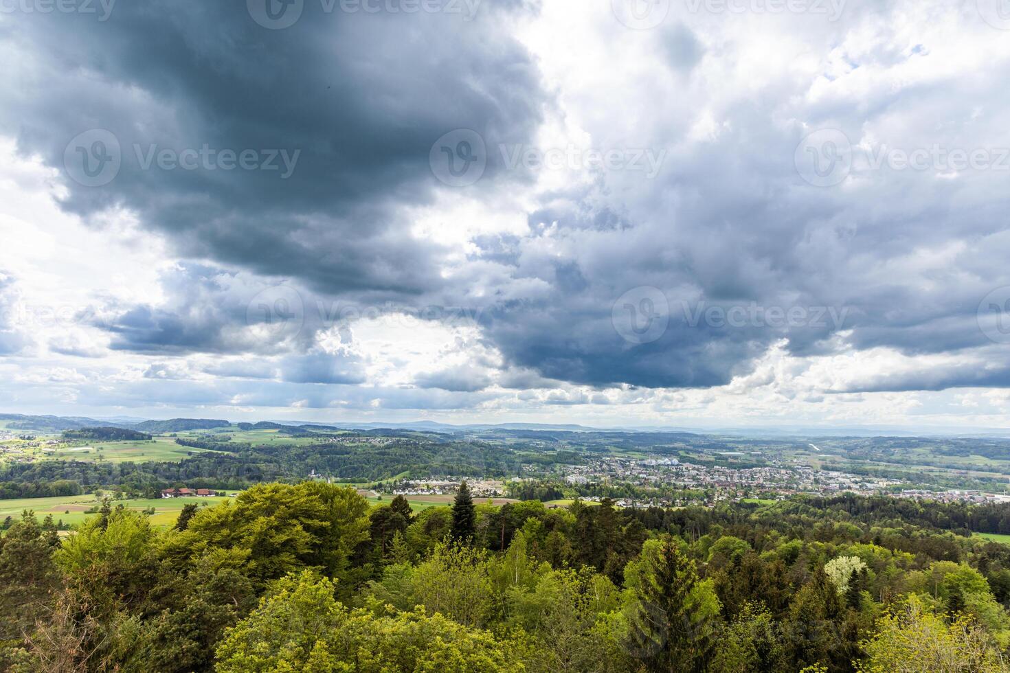fields and village on hills against a clou photo