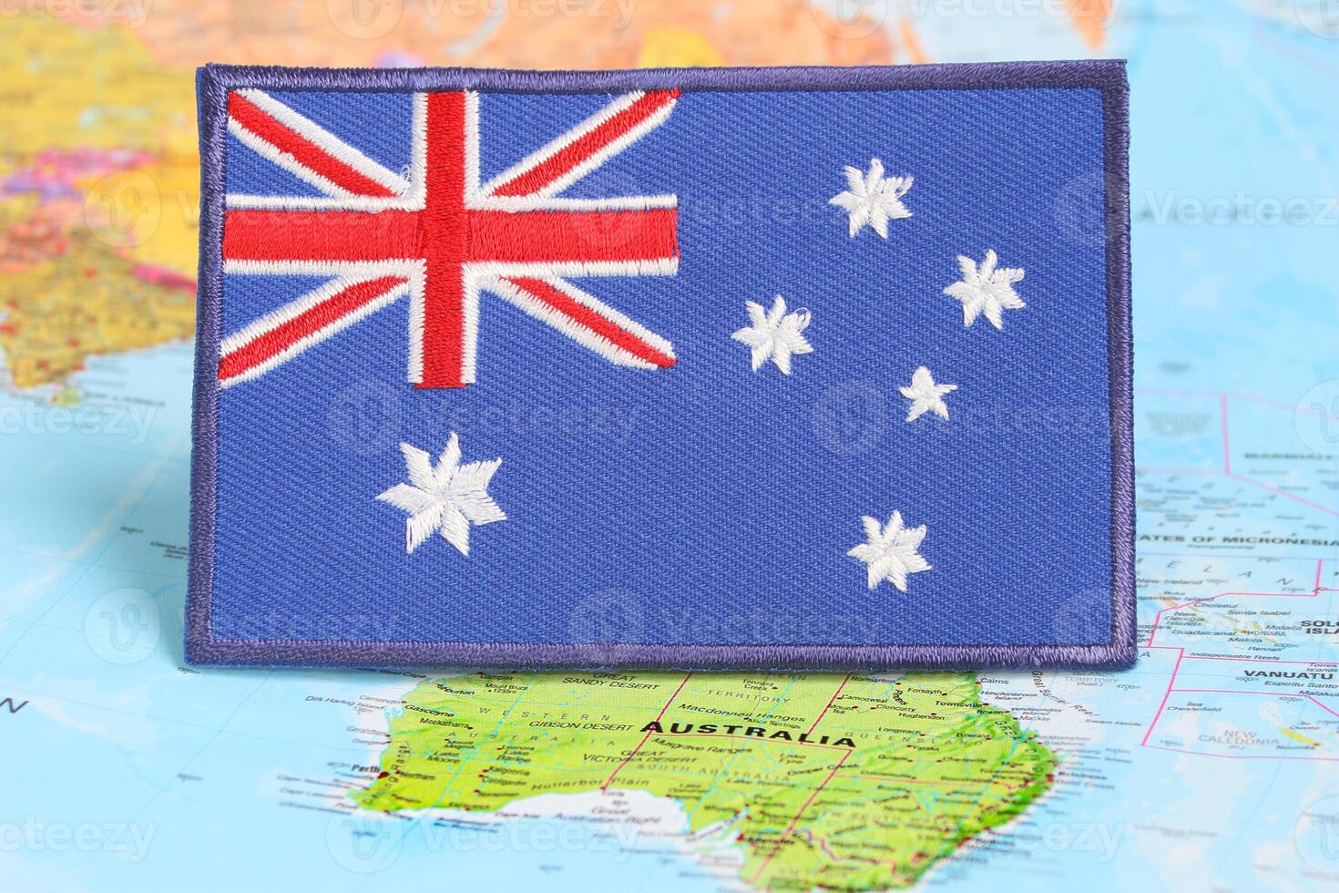 Natural fiber Australia flag embroidery on world map, marking Canberra. Earth Day, global warming awareness and national celebration in eco friendly design photo
