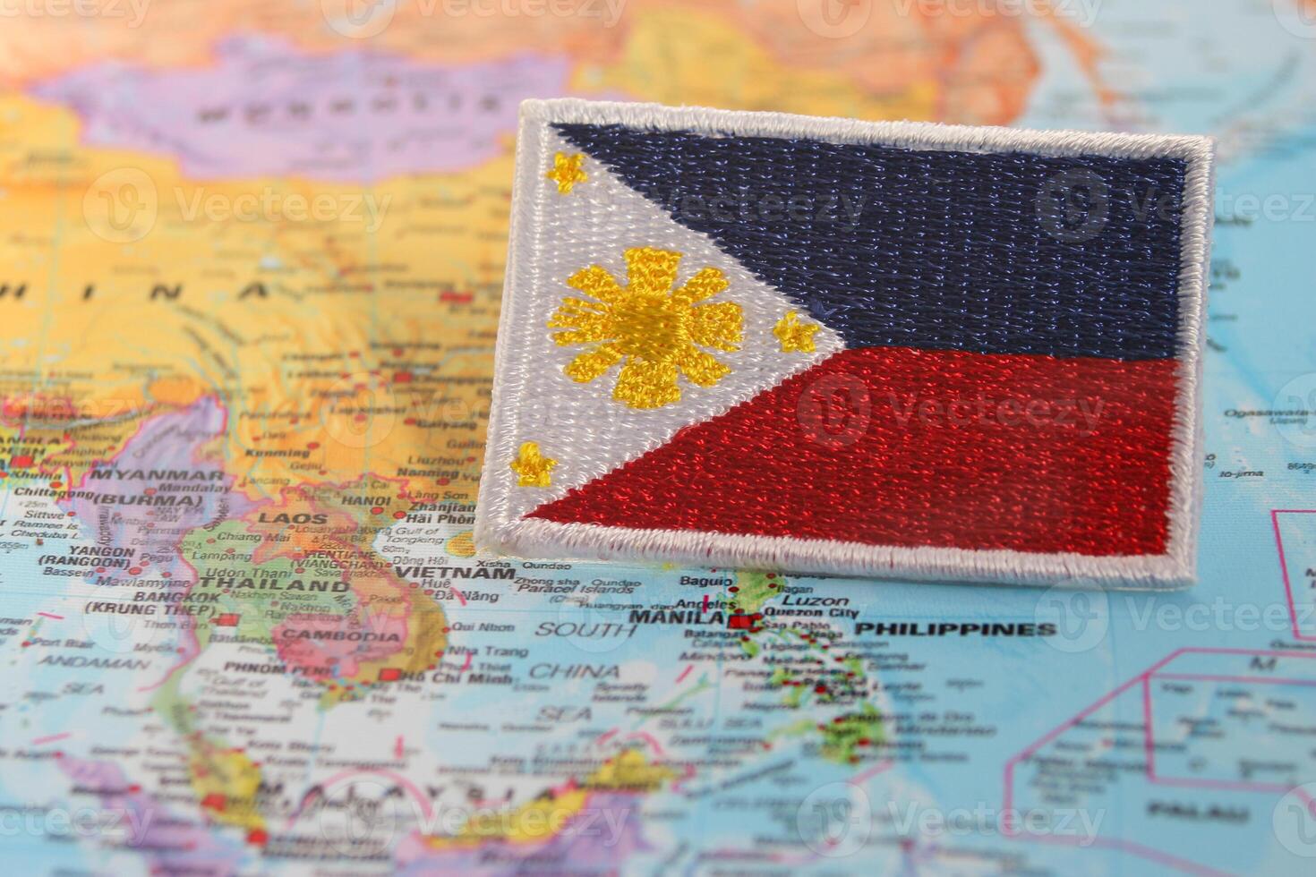 Horizontal eco friendly Philippines flag PH flag made from fabric and thread, placed over world map highlighting Manila under studio lighting. Symbolizing National Day, Earth Day photo