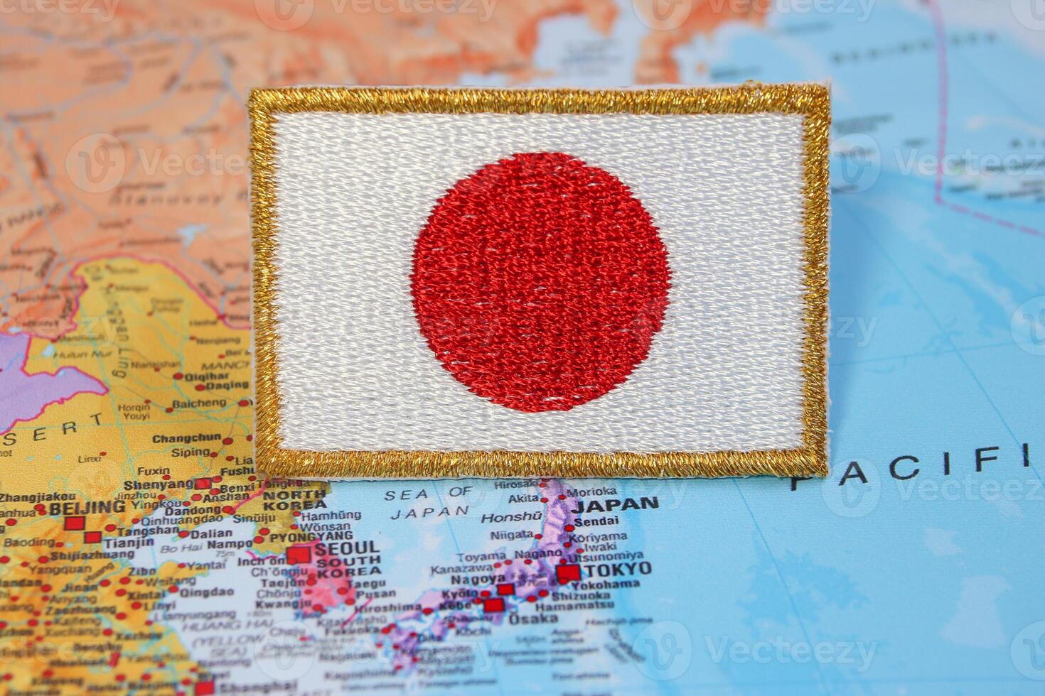 Natural embroidered Japan flag with gold border on world map marking Tokyo. Ideal for travel design, national celebrations, eco concepts and cultural pride photo