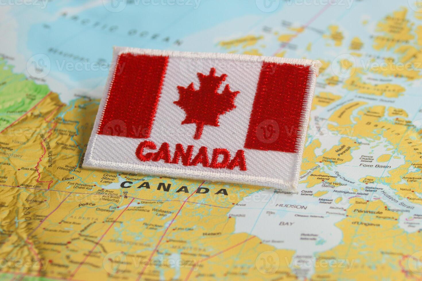 Horizontal eco friendly Canada flag CA flag embroidered with CANADA below, placed on world map highlighting Ottawa under studio lighting. Symbolizing National Day, Earth Day photo