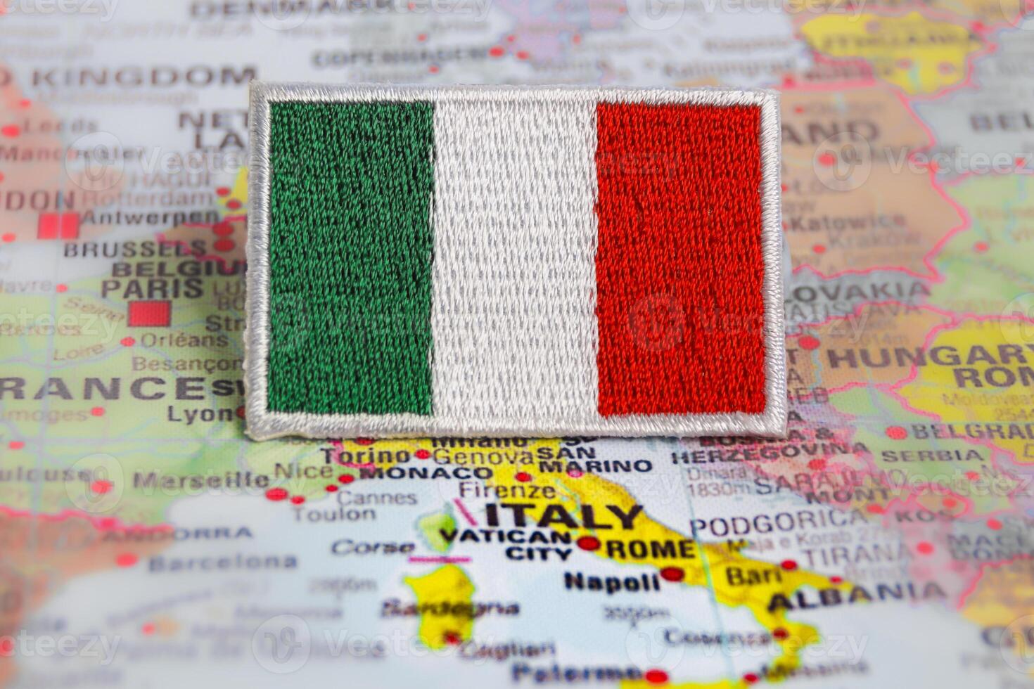 Horizontal photo of Italian Republic Flag IT flag embroidered and placed on world map at Rome, Italy. Represents travel, patriotism and cultural heritage.