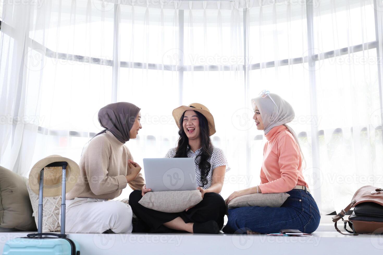 Three Asian Woman Friend Sitting at Home Preparing Itinerary using Laptop photo