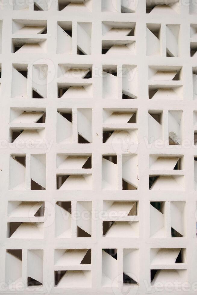 Geometric white facade with repeating square patterns, creating shadows and architectural interest photo