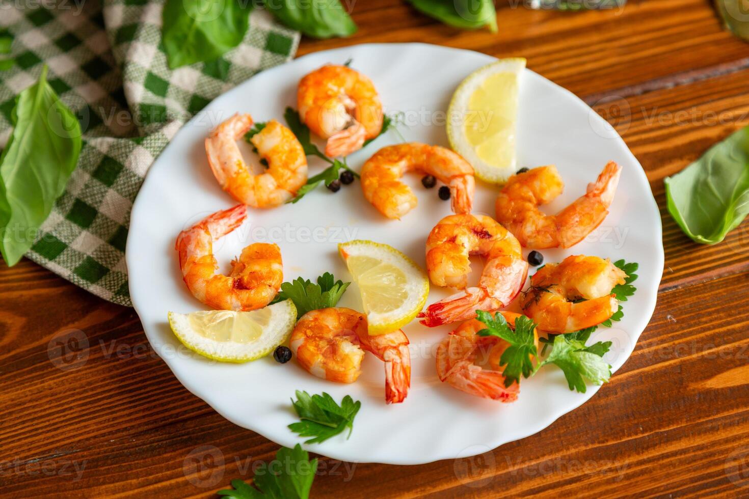 Cooking fried shrimps with aromatic spices and lemon in a plate on a wooden photo