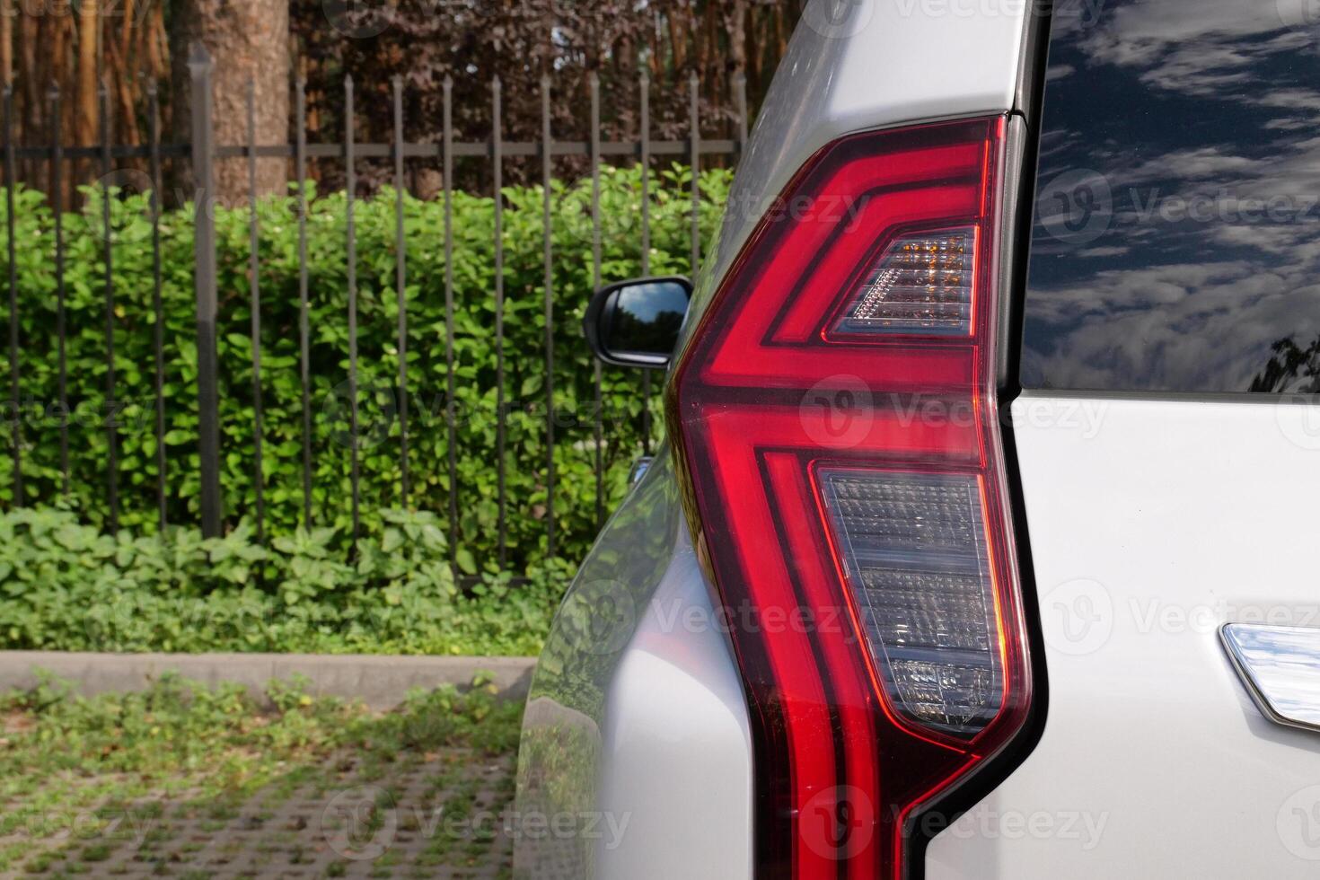 Back Light Of Vehicle Stay In Front Of Fence Of Forest Park photo