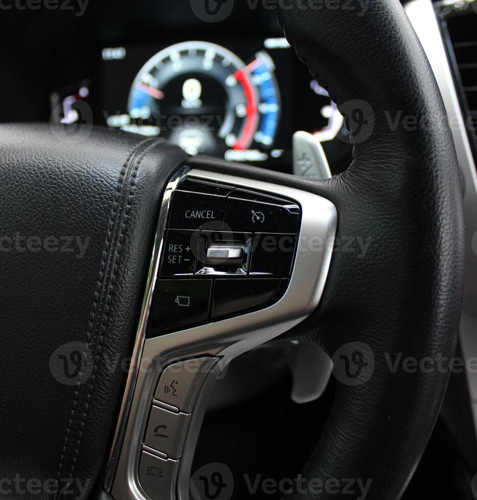 Defocused LED Dashboard Behind Steering Wheel With Control Buttons On It photo
