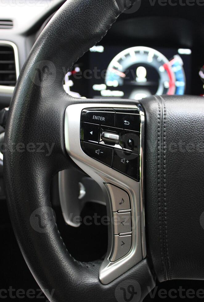 Buttons And Electronic Control Panel On A Steering Wheel And Blurred Digital Dashboard Inside Modern Car photo