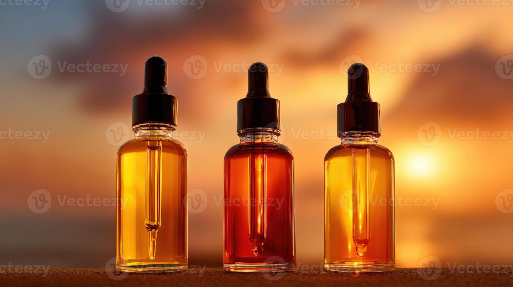 Set of three amber glass dropper bottles filled with natural hair oils against a sunset background photo