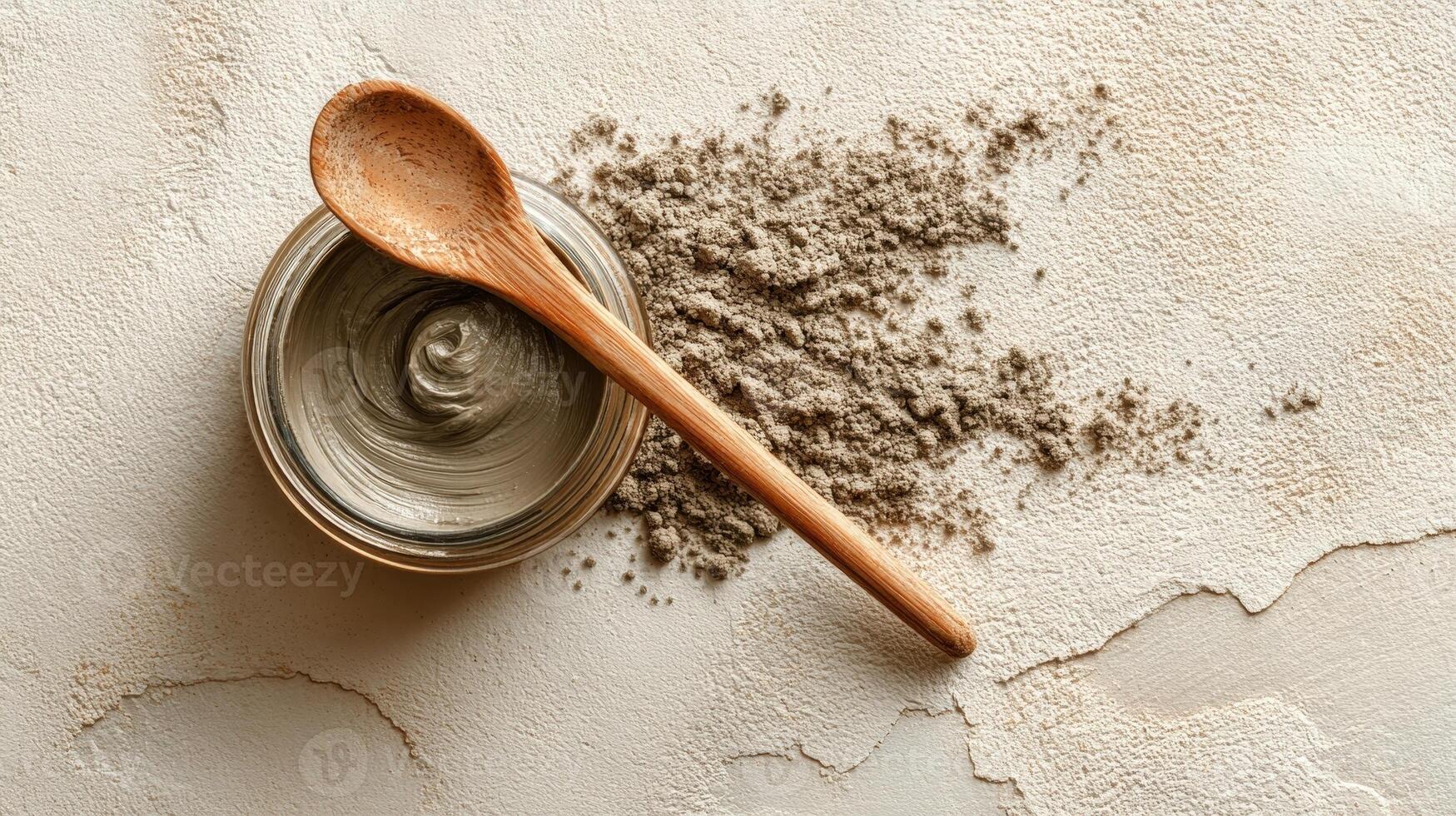 Face mask jar with wooden spoon and natural clay on off white textured surface in a serene setting photo