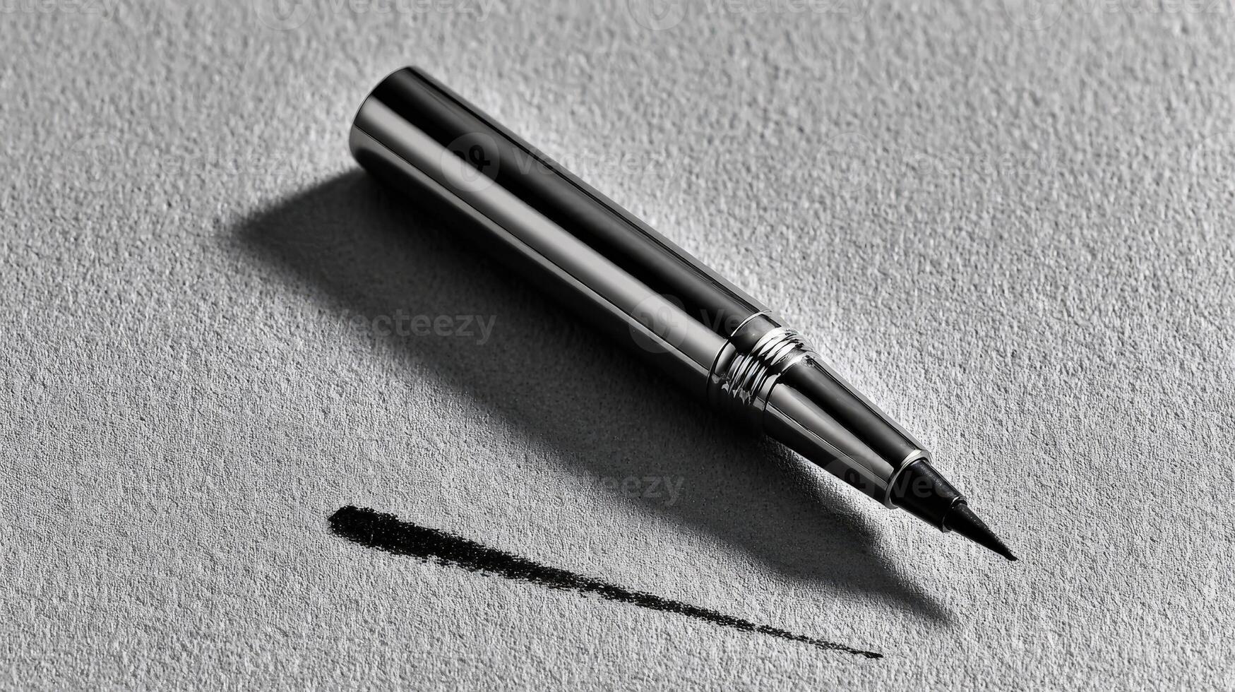 Black eyeliner pen with chrome details resting on a textured surface showcasing its sleek design and precision tip photo