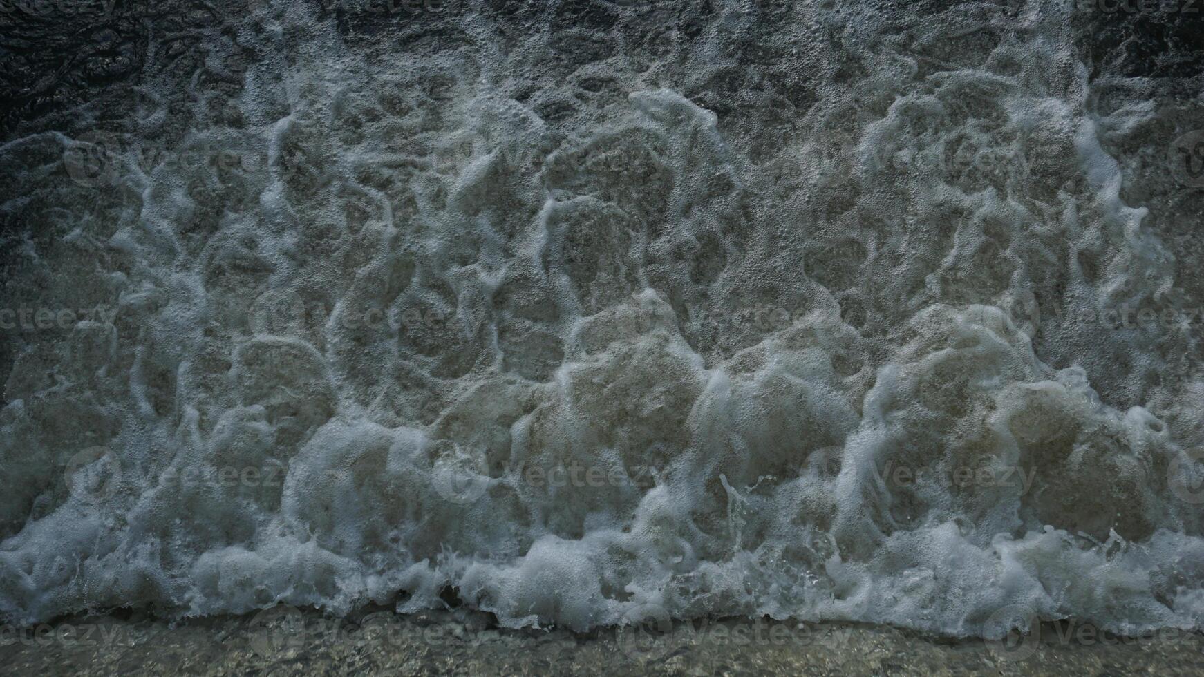 A close up of a wave crashing into the water photo