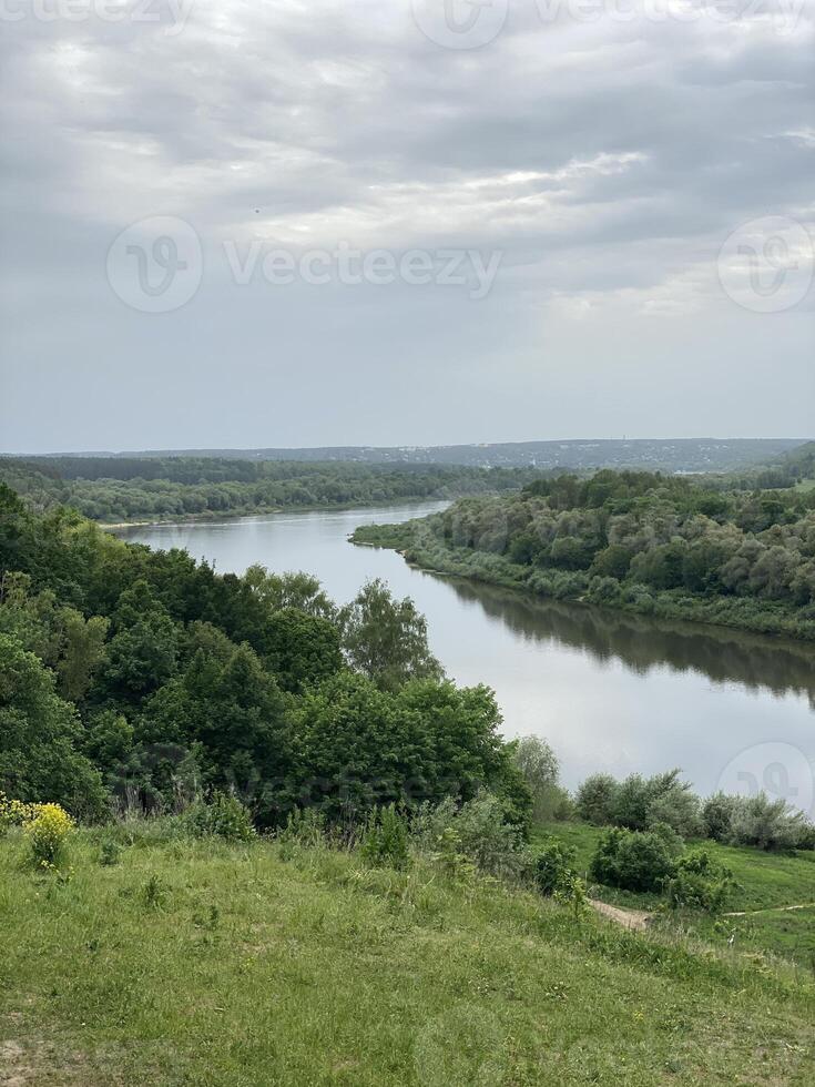 Scenic river landscape with lush greenery and cloudy sky, perfect for nature background photo
