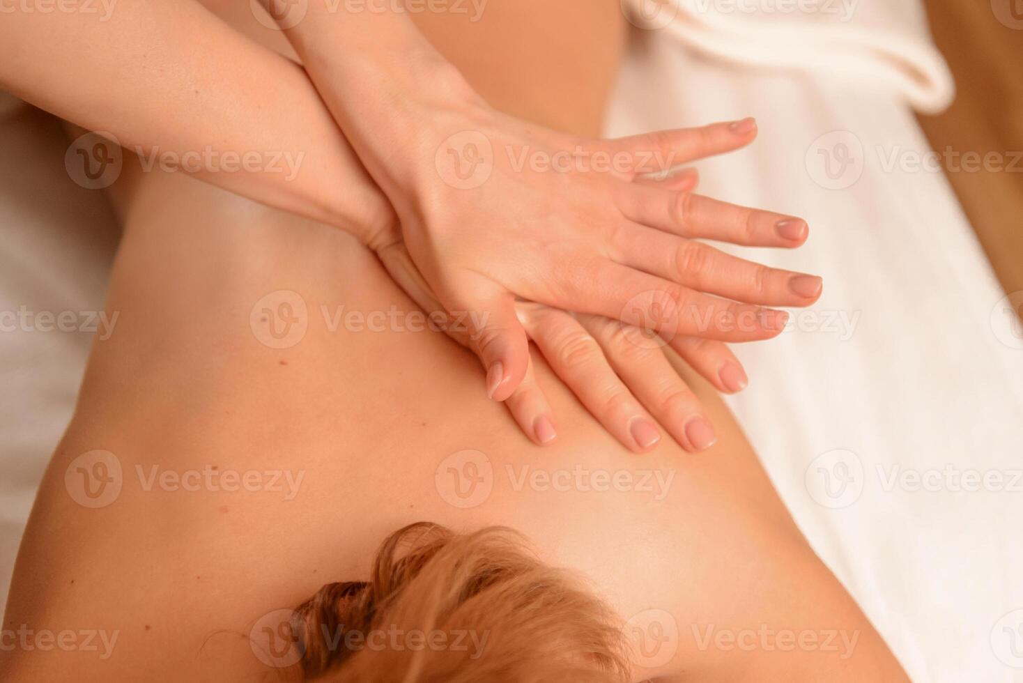 Massage therapy session Hands-on treatment for back pain relief slender Caucasian woman. Massage, health, wellness. photo