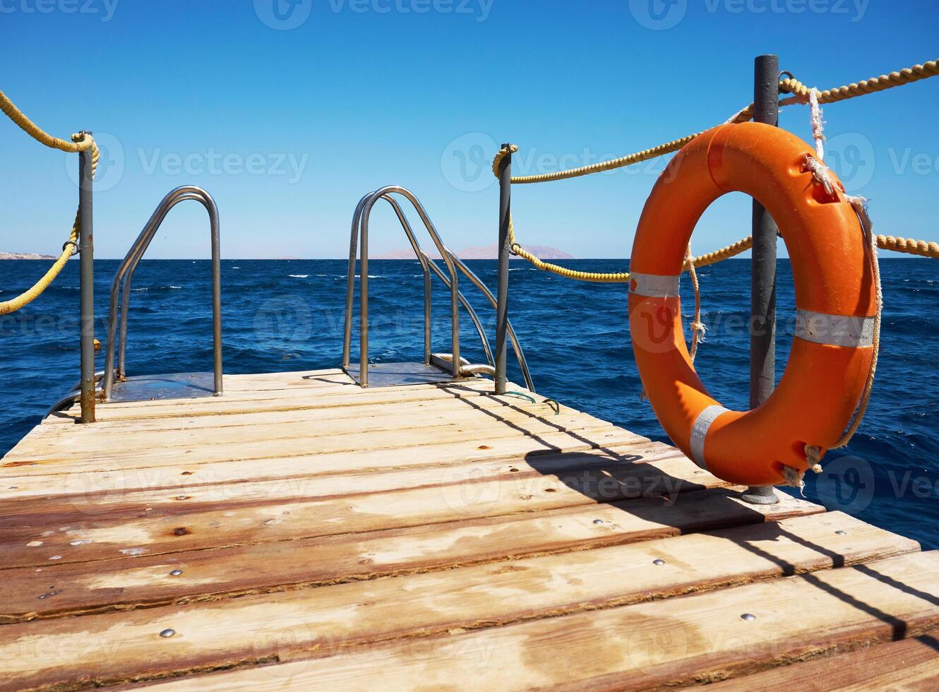 Wooden pier near the sea with lifebuoy photo