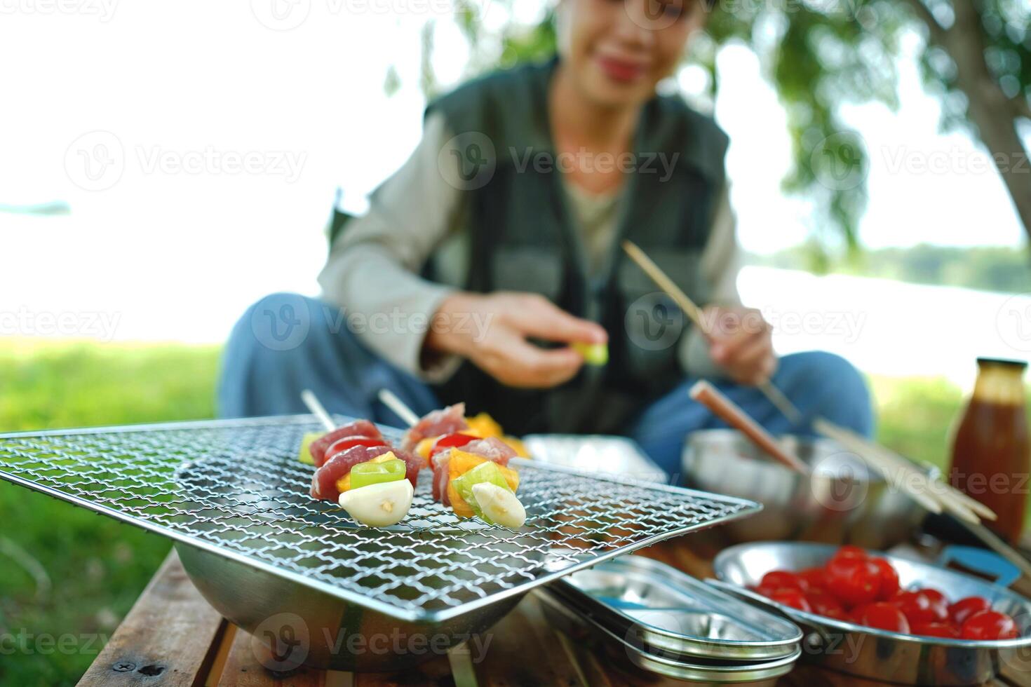 A woman is sitting on a picnic table with a plate of food in front of her photo